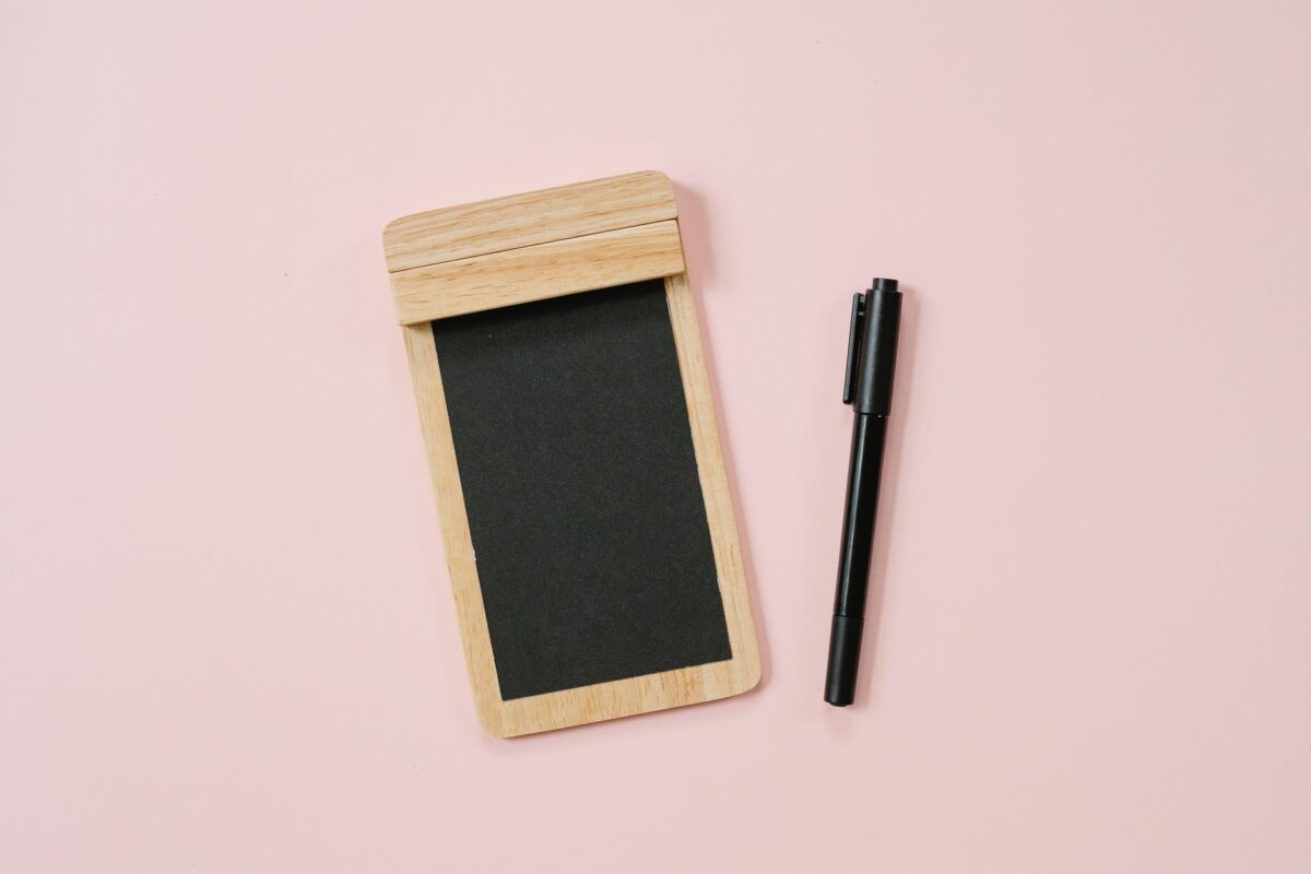pen and wooden notepad with black paper